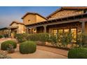 Beautiful exterior of home, boasting stone accents, large windows, mature landscaping, and an extended front porch at 7413 E Lower Wash Pass, Scottsdale, AZ 85266