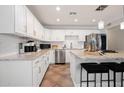 Well-appointed kitchen featuring sleek appliances, stylish white cabinets, and a large island with seating at 8213 E Whitton Ave, Scottsdale, AZ 85251
