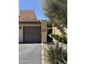 Beige townhome with brown garage door, red tile roof, and tidy landscaping at 8302 N 21St Dr # L204, Phoenix, AZ 85021