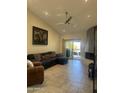Inviting living room featuring a vaulted ceiling, fireplace, ceiling fan, and sliding glass doors to the balcony at 8302 N 21St Dr # L204, Phoenix, AZ 85021