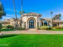 Well-maintained home featuring lush lawn, mature landscaping, circular driveway and custom entryway at 8712 N 64Th Pl, Paradise Valley, AZ 85253