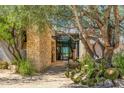 Inviting entrance features stone accents, mature landscaping, and a glimpse of the luxurious interior at 10801 E Happy Valley Rd # 4, Scottsdale, AZ 85255