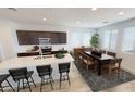 Modern kitchen boasts a spacious island with seating, dark cabinets and a dining area by windows at 12633 W Luxton Ln, Avondale, AZ 85323