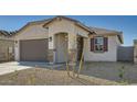 Charming home featuring a well-kept yard, stone accents, and a two-car garage at 15065 W Hackamore Dr, Surprise, AZ 85387