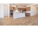Open kitchen featuring wood tile flooring, stainless steel appliances, and a center island at 1892 E Empeltre Rd, San Tan Valley, AZ 85140