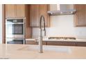 Close-up of kitchen island with stainless steel faucet, undermount sink and quartz countertop at 1892 E Empeltre Rd, San Tan Valley, AZ 85140