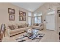 Bright living room with a vaulted ceiling, neutral-toned furniture, and decoratively framed Gathering portraits at 25038 W Rancho Vista Dr, Buckeye, AZ 85326