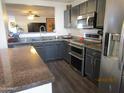 Modern kitchen featuring stainless steel appliances, gray cabinets, and granite countertops at 3004 W Running Deer Trl, Phoenix, AZ 85083