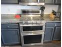 Close-up of a stainless steel double oven with granite countertops and custom cabinets at 3004 W Running Deer Trl, Phoenix, AZ 85083