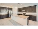 Modern kitchen with stainless steel appliances, a central island, and dark wood cabinets at 3252 W Peak View Rd, Phoenix, AZ 85083