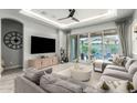 Living room featuring a large TV, modern furnishings and backyard pool view through sliding doors at 3527 E Arabian Dr, Gilbert, AZ 85296