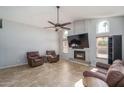 Spacious living room featuring a fireplace with tile accents and ceiling fan at 3620 N Aspen Dr, Avondale, AZ 85392