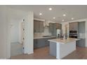 Modern kitchen with gray cabinets, stainless steel appliances, and a central island at 4050 W Nora Dr, San Tan Valley, AZ 85144