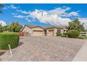 Charming single-story home featuring a three-car garage and a paver driveway and lush front landscaping at 4318 N 180Th Dr, Goodyear, AZ 85395