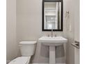 Powder room featuring pedestal sink, a modern mirror, and hardware at 5848 E Covey Ln, Phoenix, AZ 85054