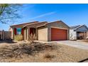Single-story house featuring a desert landscape, a red garage door, and a cozy entrance at 7456 N 126Th Ln, Glendale, AZ 85307