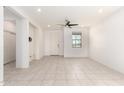Bright and open living room with neutral tile flooring, a ceiling fan, and natural light at 7456 N 126Th Ln, Glendale, AZ 85307