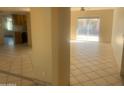 Bright and spacious living room featuring neutral tile flooring and sliding glass doors to the backyard at 8640 S 16Th Pl, Phoenix, AZ 85042