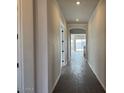 Inviting hallway featuring dark tile flooring, neutral wall colors, and elegant archway leading to living areas at 10039 W Verde Ln, Avondale, AZ 85392