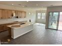 Open concept kitchen with light wood cabinetry, an island with a white countertop, and stainless steel appliances at 10039 W Verde Ln, Avondale, AZ 85392