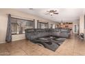 Spacious living room with a large sectional sofa, tile floors, and lots of natural light at 11872 W Sherman St, Avondale, AZ 85323