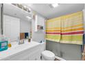 Bright bathroom with new vanity, fixtures, and shower with yellow-stripped curtain at 12123 W Bell Rd # 359, Surprise, AZ 85378