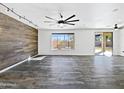 Spacious living area with wood floors, a wood accent wall, and sliding glass doors to the backyard at 1227 E Indigo St, Gilbert, AZ 85298