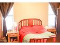 Cozy bedroom with wooden headboard, bright windows, and side tables at 16120 W Kendall St, Goodyear, AZ 85338