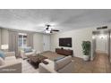A furnished living room with tile floors, neutral walls, ceiling fan, and bright natural light offers a move-in-ready space at 1633 W Andorra Dr, Phoenix, AZ 85029