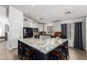 Bright kitchen features granite counters, white cabinets, modern black appliances, and an island with bar seating at 25844 W Watkins St, Buckeye, AZ 85326
