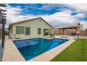 Backyard view showcasing a pool with a lounging area, and desert landscaping, perfect for relaxing and entertaining at 25844 W Watkins St, Buckeye, AZ 85326