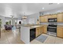 Open concept kitchen featuring wooden cabinets, stainless steel appliances, and tiled floors at 29081 N Cactus Cir, San Tan Valley, AZ 85143