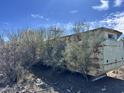 Exterior view with aged structure surrounded by desert vegetation and clear sky at 3200 S Mesa Rd, Winkelman, AZ 85192