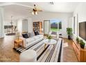 Bright living room features modern furniture, wood floors, ceiling fan, and sliding glass doors to the yard at 3527 N Kashmir --, Mesa, AZ 85215