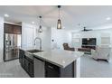 Bright, open kitchen featuring a large island with a sink and stainless steel appliances at 37051 N Rhinelander Dr, San Tan Valley, AZ 85140