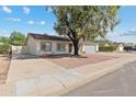 Inviting home featuring desert landscaping, mature shade tree, and extended driveway at 419 N Valencia Dr, Chandler, AZ 85226
