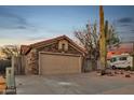 A single-story home with desert landscaping featuring a two-car garage, RV parking and stacked stone facade at 446 W Sereno Dr, Gilbert, AZ 85233