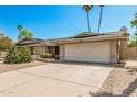 Single-story home with a wide driveway, two-car garage, and desert landscaping at 4509 E Beverly Ln, Phoenix, AZ 85032