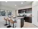 Modern kitchen with stainless steel appliances, granite countertops and island with bar stool seating at 5758 E Smeaton Pl, San Tan Valley, AZ 85140