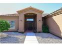 Inviting front entrance with a covered porch and desert landscaping leading to the front door at 6323 E Nisbet Rd, Scottsdale, AZ 85254