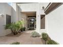 Welcoming front entrance with stone pathway, desert landscaping, and a modern glass door at 6340 E Marioca Cir, Scottsdale, AZ 85266