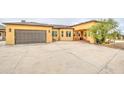 Attractive stucco home with a well-maintained driveway, garage, and comfortable front porch at 8210 S 132Nd Ave, Goodyear, AZ 85338