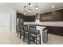 Gourmet kitchen featuring dark wood cabinets, sleek countertops, and a spacious center island at 11607 W Marguerite Ave, Avondale, AZ 85323