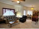 Comfortable living room featuring plush seating, large windows, and a classic ceiling fan and a coffee table at 145 N 74Th St # 236, Mesa, AZ 85207