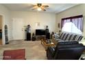 Cozy carpeted living room with ceiling fan, a sofa, a chair and a door leading to another room in the house at 145 N 74Th St # 236, Mesa, AZ 85207