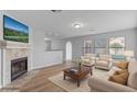 Bright living room featuring a cozy fireplace, light wood floors, and comfortable seating area at 1518 E Mineral Rd, Gilbert, AZ 85234