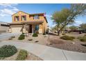 Inviting front yard with desert landscaping, a sidewalk, and an American flag at 18040 W Louise Dr, Surprise, AZ 85387