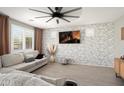 Stylish living room featuring a brick accent wall, modern furniture, and a ceiling fan at 18040 W Louise Dr, Surprise, AZ 85387