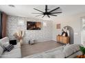 Bright living room with modern decor, a sectional sofa, and a brick accent wall at 18040 W Louise Dr, Surprise, AZ 85387