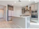 Bright kitchen featuring an island, modern appliances, sleek cabinets, and a stylish tile floor at 19801 W Badgett Ln, Litchfield Park, AZ 85340